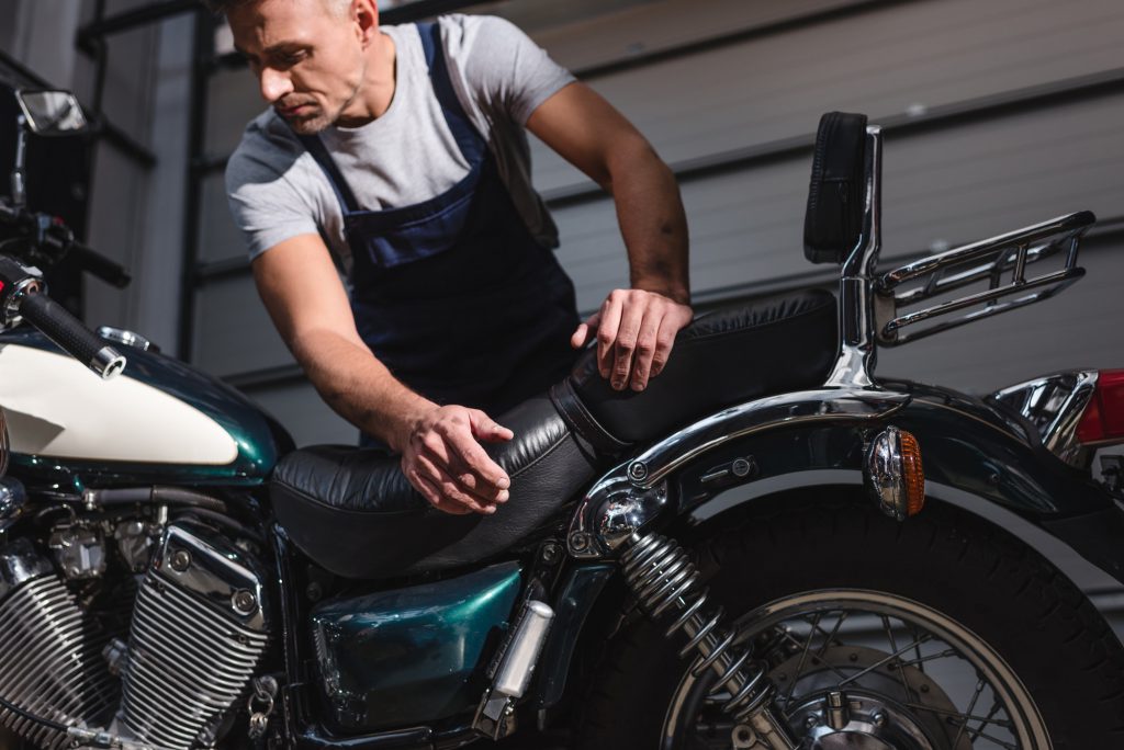 mechanic checking motorbike engine in garage